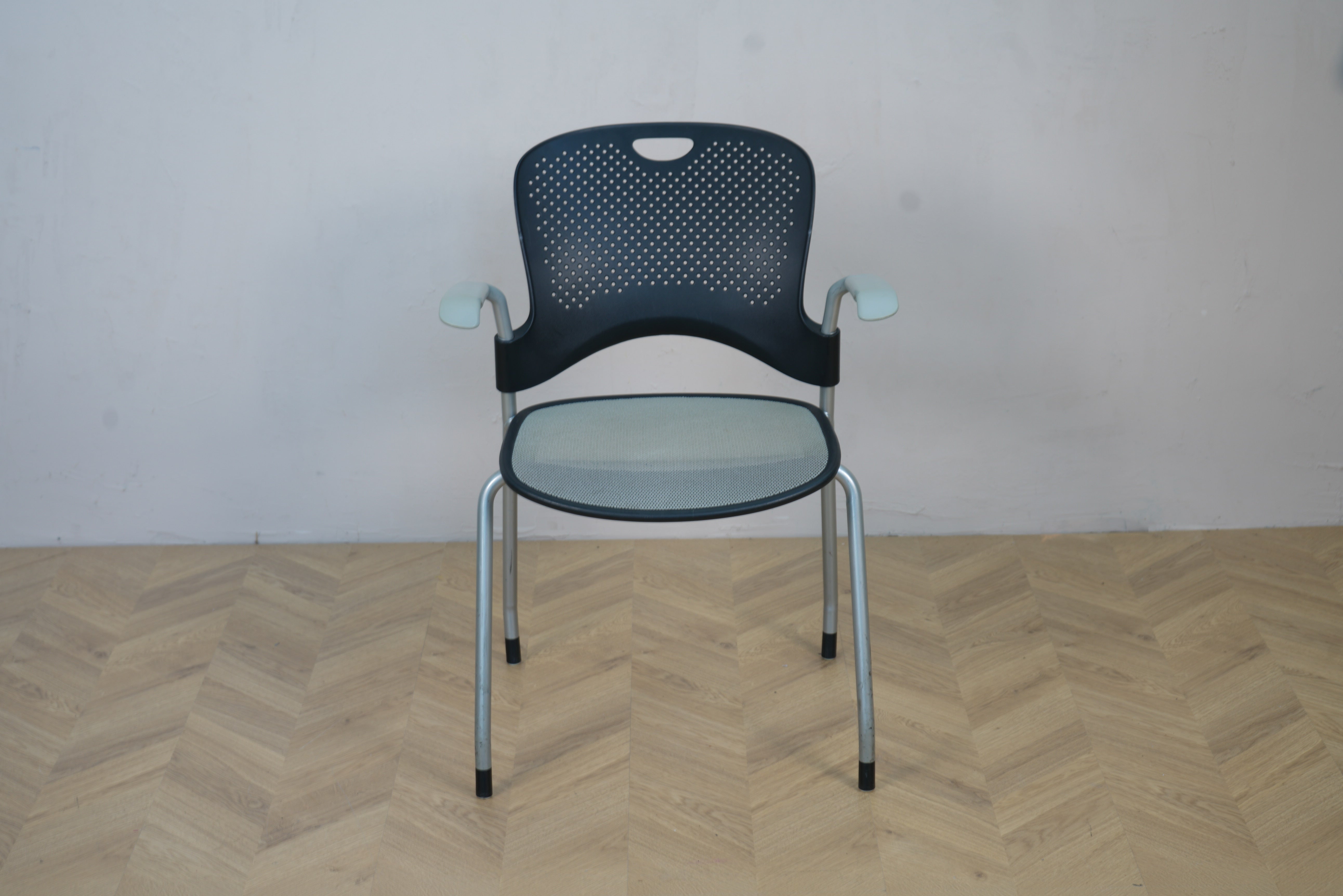 Herman Miller Casper konferencestol set forfra med sort plast ryglæn, armlæn og gråt netsæde.